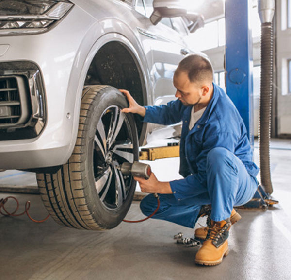 Technician removing bolts from tire